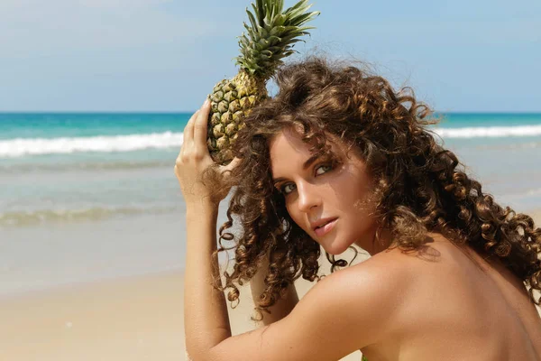 Kıvırcık Saçlı Güzel Kadın Ananas Meyve Plaj Düzenliyor — Stok fotoğraf