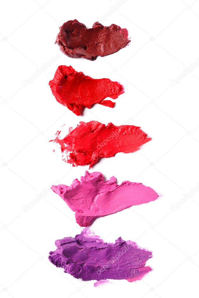 Different multi colored samples of a smudged lipstick over white background