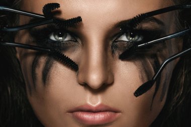 Lekeleri yüzü ve kırık maskara fırçalar makyaj, güzel bir kadınla