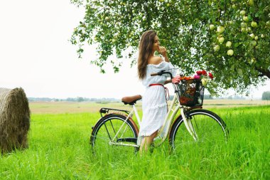 Bisiklet Köyü bahçede elma ağacı yakınındaki güzel kadınla