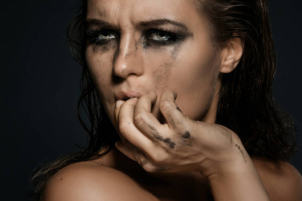 Грустная и красивая женщина с размазанным макияжем на лице
