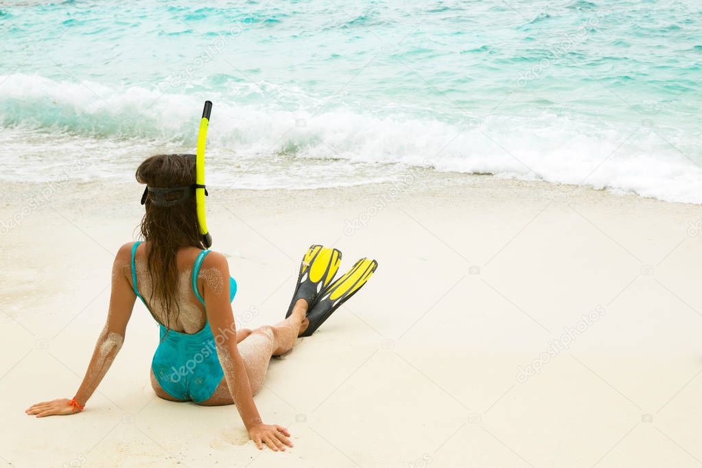 Beautiful woman with mask and flippers for snorkeling on beach