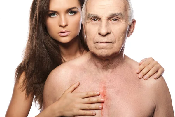 Elderly father after heart surgery and his beautiful daughter on white background