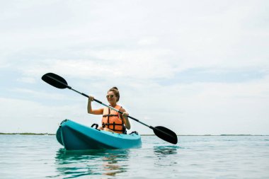 Mutlu genç güzel kadın gölde Kayak
