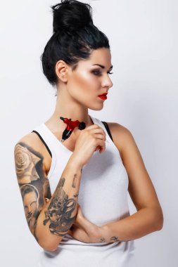 Young woman tattooist with a tattoo-machine in her hand on white background clipart