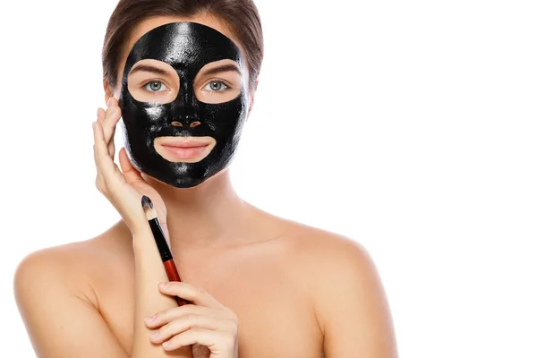 Beautiful Woman Applying Purifying Black Mask Her Face White Background — Stock Photo, Image