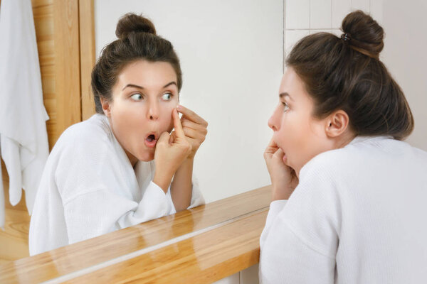 Женщина сжимает прыщи в ванной
 