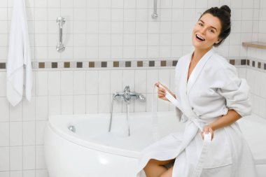 Genç kadın bir köpük ile banyo yapmak hazırlanıyor