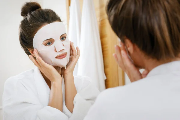 女人在浴室的脸上涂床单面具 — 图库照片