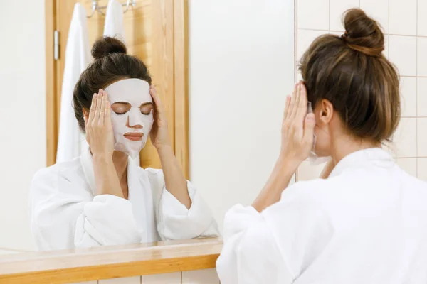 Woman Applying Sheet Mask Her Face Bathroom — Stock Photo, Image