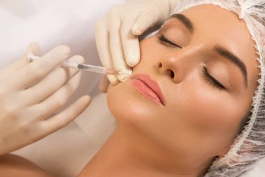 Woman during lips augmentation procedure.  clipart