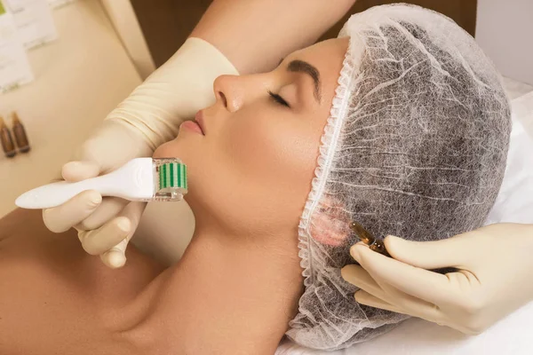 Güzellik Salonu Mezoterapi yordamı sırasında güzel kadın. Yüz microneedling tedavi meso rulo.
