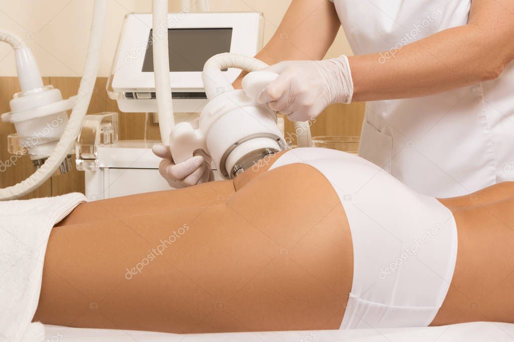 Woman during anticellulite massage or figure correction procedure