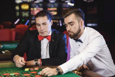 Casino rulet oynamaya iki yakışıklı adam
