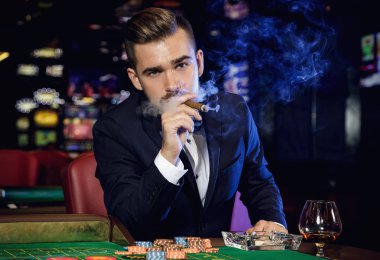 Zengin yakışıklı adam yasaktır puro ve Casino rulet oynamak
