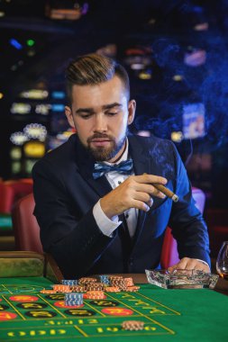 Zengin yakışıklı adam yasaktır puro ve Casino rulet oynamak