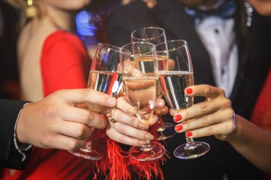 Group of people during celebration. Hands with a full glasses of sparkling wine.  clipart