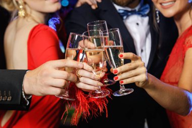 Group of people during celebration. Hands with a full glasses of sparkling wine.  clipart