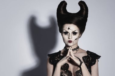 Yaratıcı görüntü Cadılar Bayramı için model. Kafasındaki boynuzları ürkütücü porselen bebek.