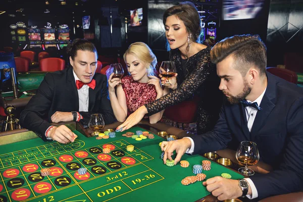 Young rich people playing roulette in casino