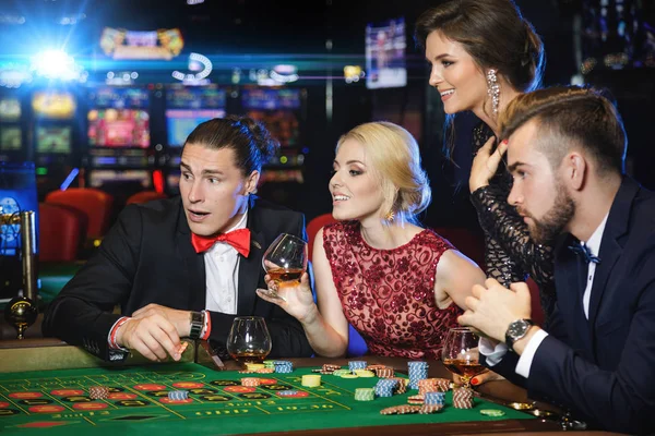 Young rich people playing roulette in casino