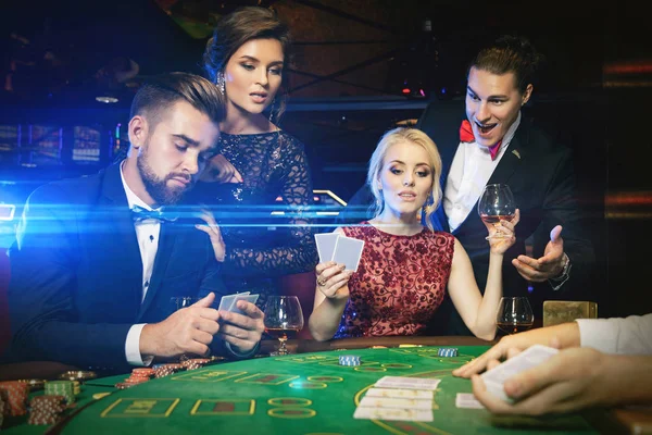 Group of young rich people playing poker in the casino