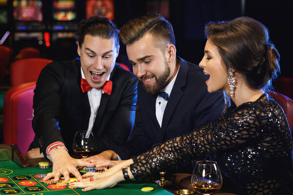Group of young rich people playing roulette in casino