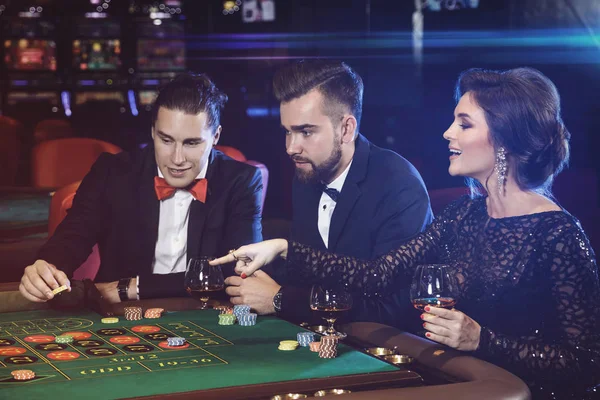 Group of young rich people playing roulette in casino