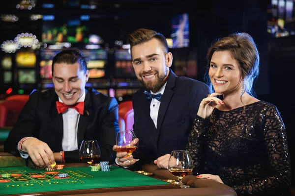 Group of young rich people playing roulette in casino