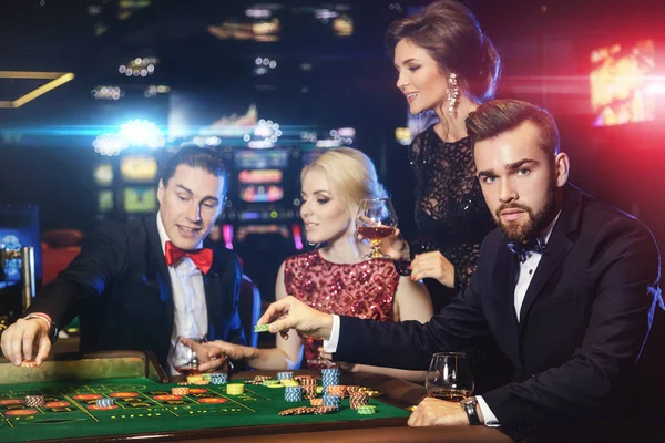 Молодые богачи играют в рулетку в казино Стоковая Картинка