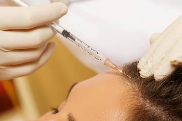 Woman getting injection for hair growth