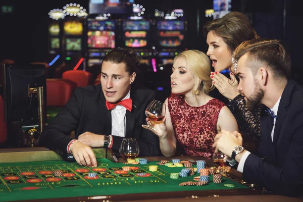 Young, well dressed and rich people playing roulette in the casino