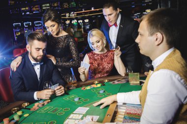 Bir grup genç zengin kumarhanede poker oynuyor.