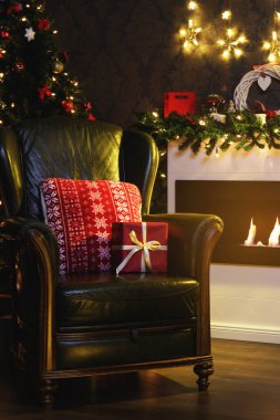 Noel hediyeleri ve koltuk şömine yanında