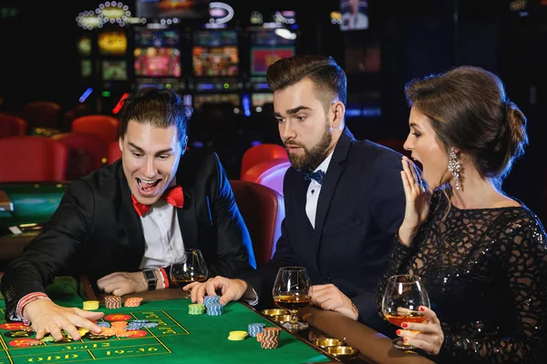 Group of young rich people playing roulette in the casino