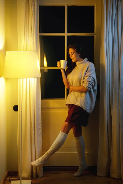 Όμορφη Γυναίκα Που Φοράει Ζεστά Πουλόβερ Και Κάλτσες Πίνοντας Ζεστό — Φωτογραφία Αρχείου