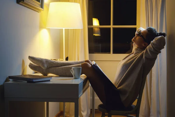 暖かいウールのセーターを着ている女性は 夜の真ん中で本を読んでいます — ストック写真