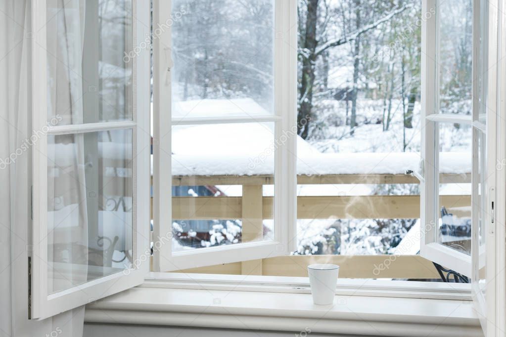 Frosty and snowy day - Cup of hot drink on the windowsill. 