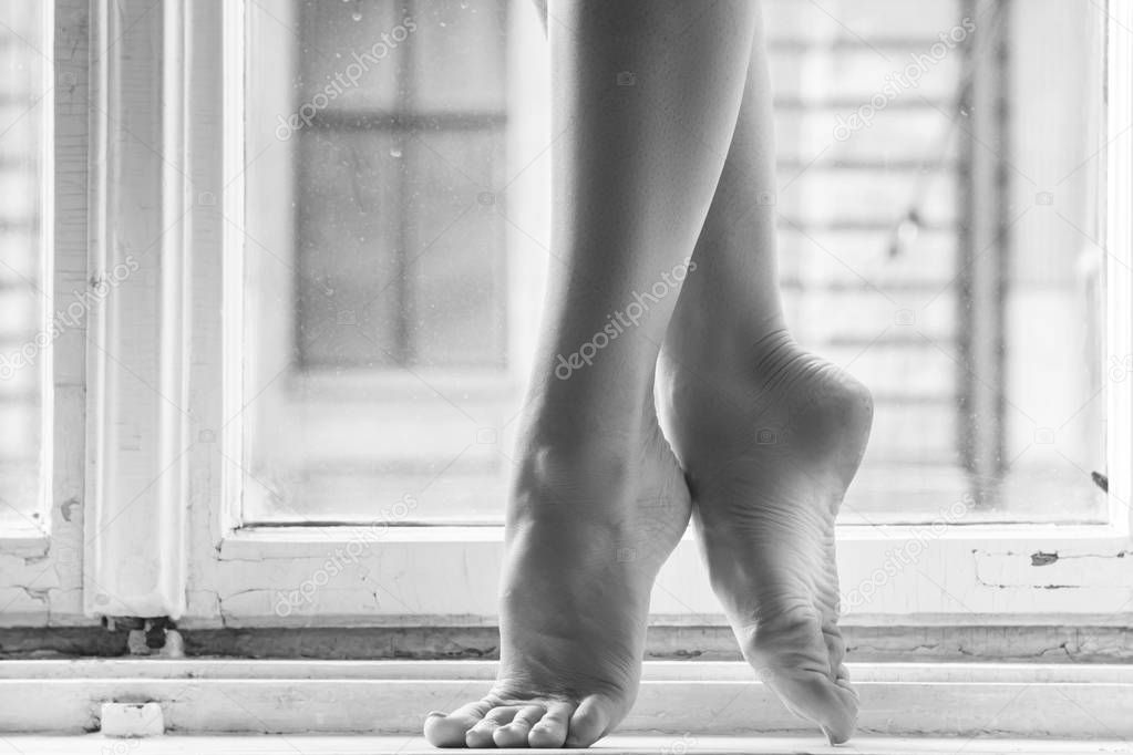 Beautiful female legs on the windowsill