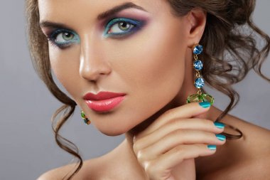 Güzel makyajlı, saç stili, parlak Earrin giyen bir kadın.