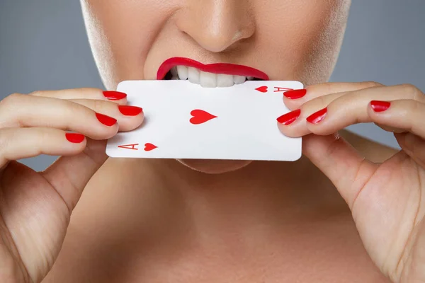 Woman with red lips is holding ace card in her hands — 스톡 사진