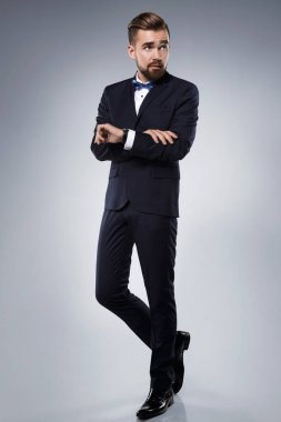 Şık yakışıklı adam papyon ile klasik bir takım giyiyor