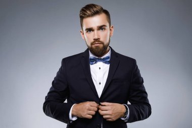 Şık yakışıklı adam papyon ile klasik bir takım giyiyor