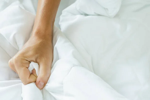 Hand squeezing bed sheet — Stock Photo, Image