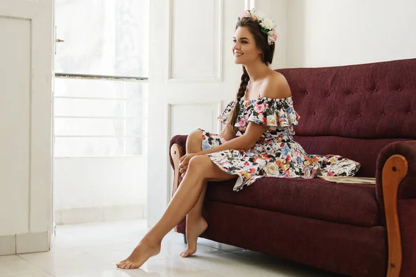 Mujer feliz en hermoso vestido está sentado en el sofá vintage —  Fotos de Stock