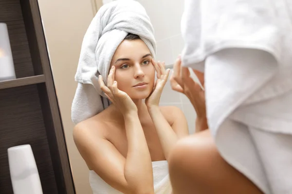 Beautiful woman is looking in the mirror — Stock Photo, Image