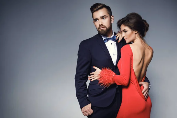 Güzel kırmızı elbiseli kadın ve mavi klasik takım elbise giyen adam — Stok fotoğraf