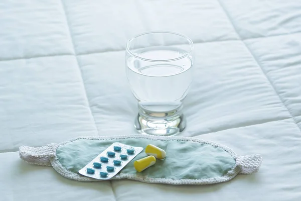 Blister de pastillas para dormir, venda para los ojos y vaso de agua —  Fotos de Stock