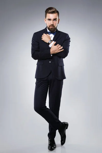 Elegante homem bonito vestindo um terno clássico com laço — Fotografia de Stock