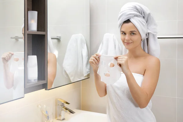 Vrouw in de badkamer is het toepassen van gezichtsmasker — Stockfoto
